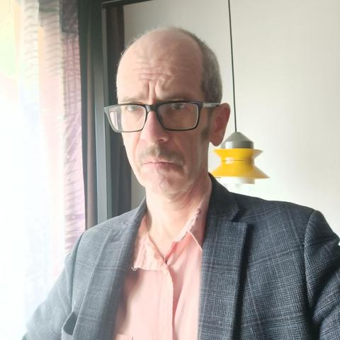 A worried looking man wearing a jacket and shirt.