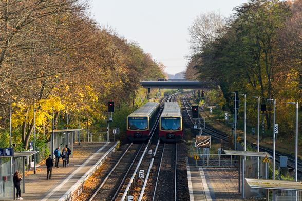 Two yellow-red s-bahn trains going past each other