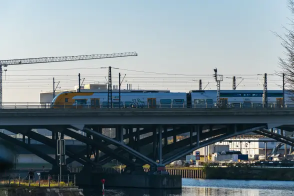 Orange-white train on a bridge, viewed from side
