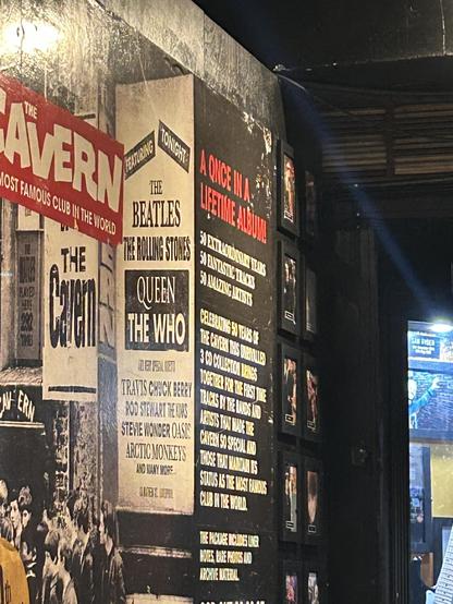 A wall with various posters about famous bands and music events, including The Beatles, Queen, The Who, and The Rolling Stones.