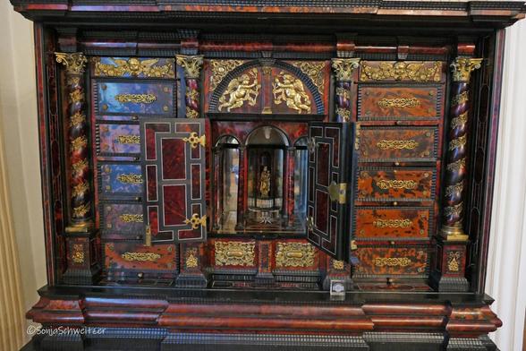 Ein Schrank mit Marienfugur und bunten Intarsien
