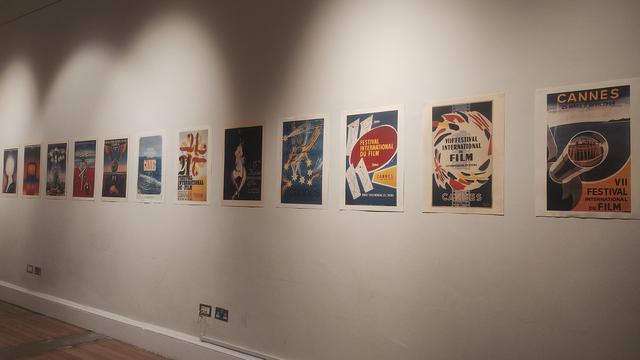 A row of vintage Cannes film festival posters on an exhibition wall