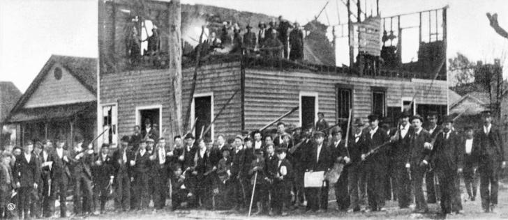 Mob posing by the ruins of The Daily Record. By Unknownderivative work: MagentaGreen - This file was derived from: Wilmington vigilantes.tif:, Public Domain, https://commons.wikimedia.org/w/index.php?curid=43151021
