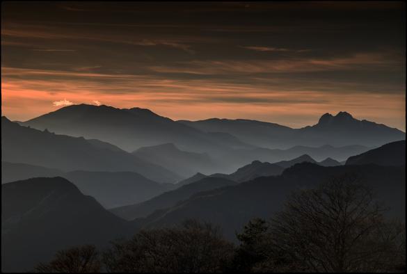 CAT
En mig de les valls,
com d'amagat,
hi ha pobles,
hi viu gent.
Ara es fa de nit
i res de tot això
és massa palés.
Deu haver-hi gent
fent foc a la llar,
hi ha qui deu 
preparar el sopar
i fins hi tot potser
algú està llegint.
Però de tot això 
no em sabem res.
Només allò que som
capaços d'imaginar.

OC
Al mitan de las valadas,
coma s'amagat,
i a de vilatges,
de monde i vivon.
Ara es nuèit
e res d'aquò
es tròp evident.
I deu aver de monde
fasent un fuòc dins lo fogal,
qualqu'un deu èsser
preparar lo sopar
e benlèu quitament
qualqu'un legís.
Mas nosautres
saber pas res sus tot aquò.
Sonque çò que
pòt imaginar.