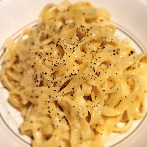Teller mit Fettucine, einer Butter-Parmesan-Soße und etwas Pfeffer.
