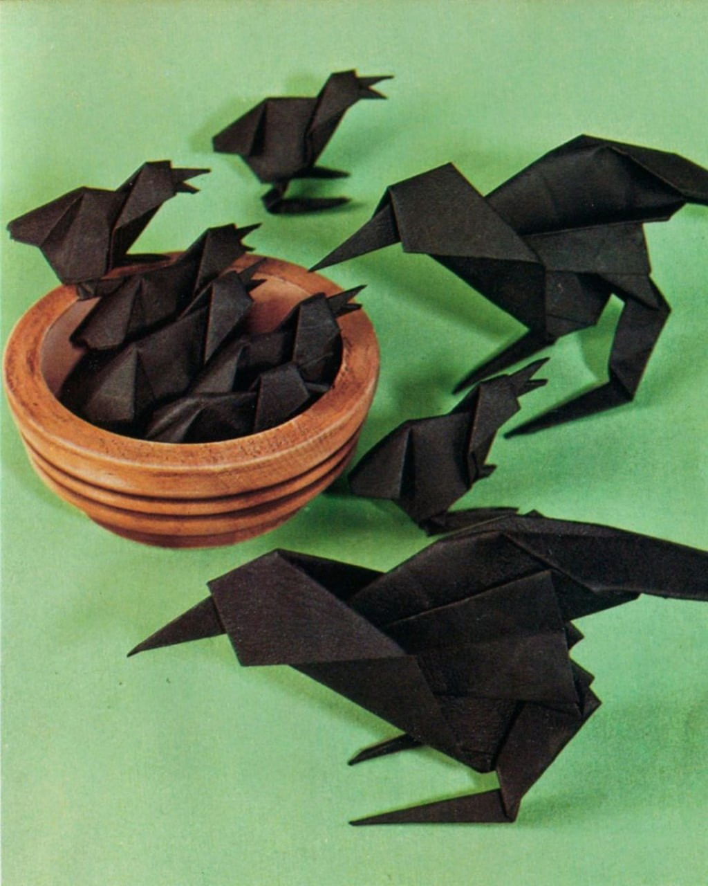 Origami by Toyoaki Kawai, Japan, 1982 Made from black paper A family of crows, two large ones and many little ones, some in a bowl that serves as a nest