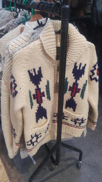 Heavy, white knitwear cardigan with pockets and coloured, geometric patterns