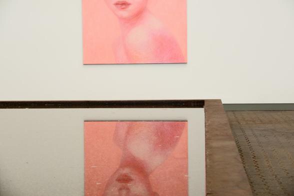 A painting of a head of a young woman reflected in a water surface