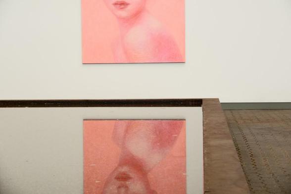 A painting of a head of a young woman reflected in a water surface