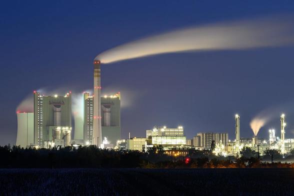 Instalaciones de la central termoeléctrica de lignito de Schkopau (Alemania), iluminadas bajo el cielo oscuro de la mañana. (Hendrik Schmidt / picture alliance via Getty Images)