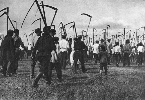 People march carrying scythes.