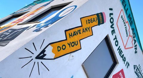 photo of some graffiti on a wall - it is of an orange pencil and the pencil is a zig zag shape and on it it reads 'do you have any idea?'
