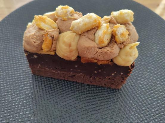 Pâtisserie au chocolat avec des noisettes sur une assiette noire