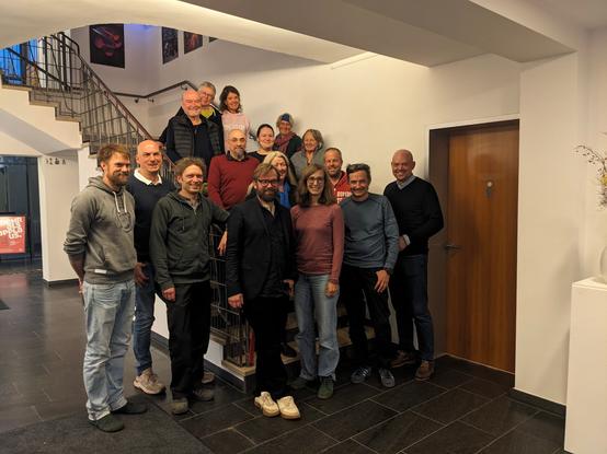 16 Menschen, stehen vor und auf einer Treppe, alle kandidierende auf der MfG/PIRATEN Liste.
Junge und ältere, Frauen und Männer und alle lächeln freudig in Richtung der Fotografen.

Vorne in der Mitte mit Brille und Anzug, Bürgermeisterkandidat Stefan Berchtold.
Vorne in der Mitte mit ebenfalls mit Brille, Valeria Mayer.
Vorne der zweite von Rechts, Axel Höpner.
Vorne der dritte von Links: Tobias McFadden(aka Kalle).