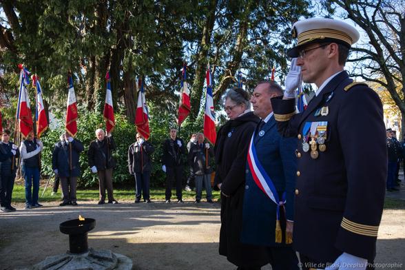 Le maire, Marc Gricourt, entouré de l’adjointe au maire à la mémoire, Christelle Leclerc, et du délégué militaire départemental, le colonel Benoît Cornu, observent avec la foule une minute silence devant la flamme du souvenir, avec les porte-drapeaux des associations patriotiques en arrière-plan.