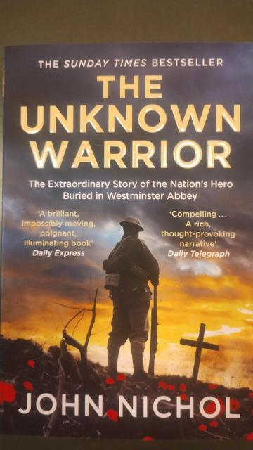 the cover for The Unknown Warrior by John Nichol, showing a WWI "Tommy", his back to us, contemplating a poppy-covered grave as the sun sets