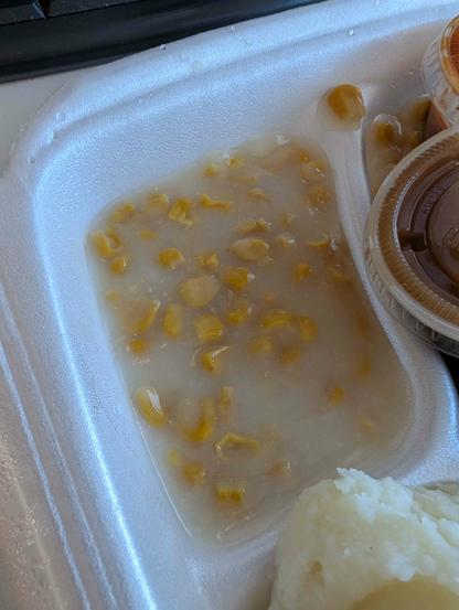 very wet creamed corn in a Styrofoam takeout tray from a barbecue joint