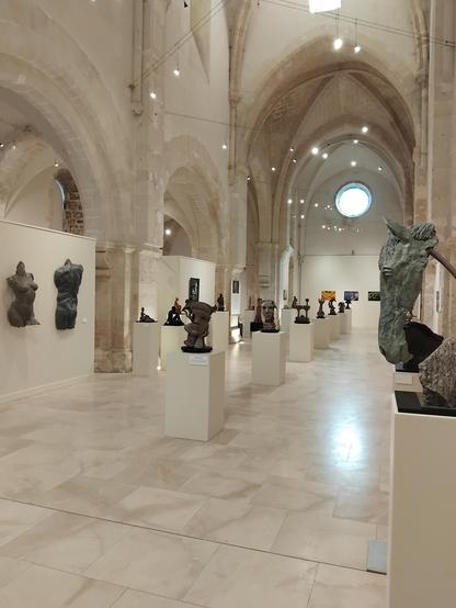 Exposition de sculpture dans une une grande ancienne église gothique en pierre blonde