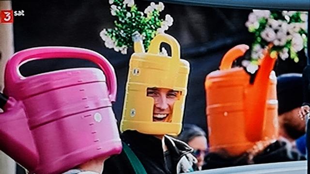 Drei Typen mit giesskannen auf dem Kopf, Boden abgeschnitten, gucklöcher für Mund und Augen, wie Helm übergestülpt.