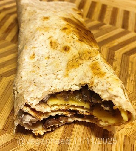 A bowl of Carrot & Ginger Soup, topped w/ fresh cucumber & tomato. Served w/ Wholemeal Taco stuffed with Spiced Black Beans & Fried Vegetables.