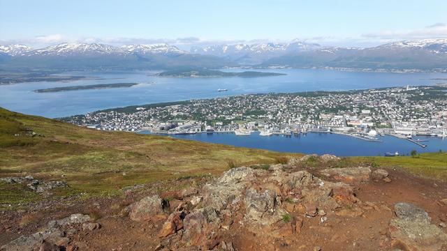 Kuva edellistä reunemmalta, jolloin Tromssan keskustan saari näkyy, vuonoa molemmin puolin, ja tausta sama kuin edellä.