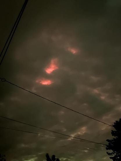 aurora behind some clouds, red, looking like a face in the sky