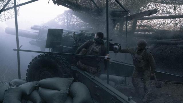 Nella fotografia, un'immagine di guerra con alcuni militari all'interno di una trincea.