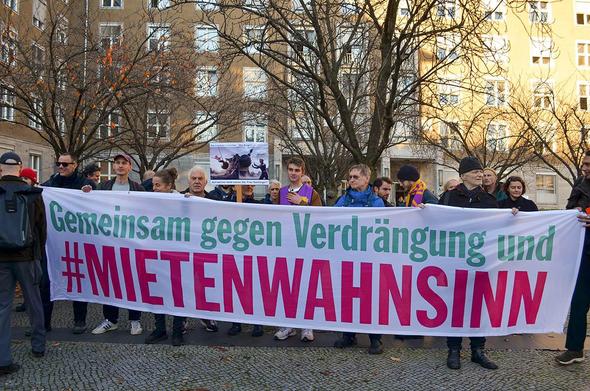 Das Foto von © Monika von Wegerer zeigt eine Gruppe von Teilnehmer:Innen der Aktion, die hinter einem Transparent stehen. Der Text auf dem Transparent lautet: "Gemeinsam gegen Verdrängung und #Mietenwahnsinn"