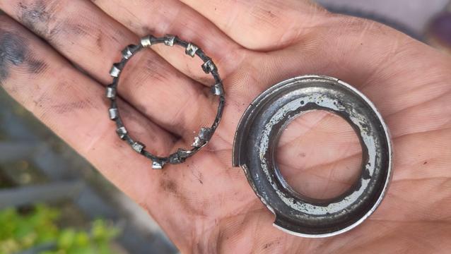 Dans ma main, la cuvette et la cage des billes du jeu de direction précédent.
La cuvette et cassée sur un côté et la cage est déformée avec des ergots qui devraient retenir les billes cassés.
Il n'y a aucune graisse et je n'ai rien nettoyé