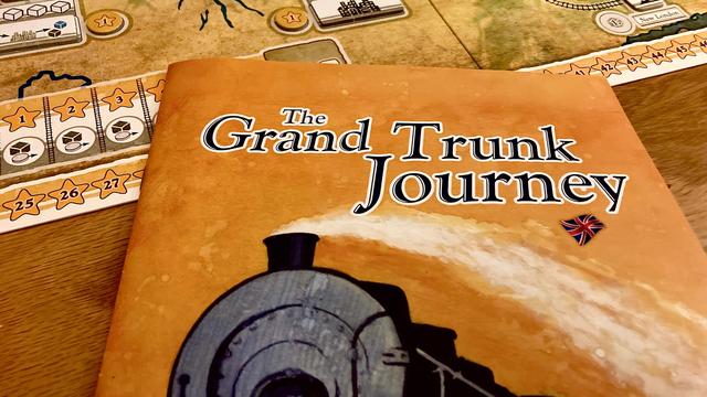 the rulebook of The Grand Trunk Journey next to the game board