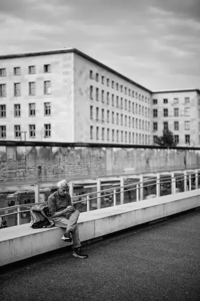 Person looks at their phone while sitting down in a stone bench