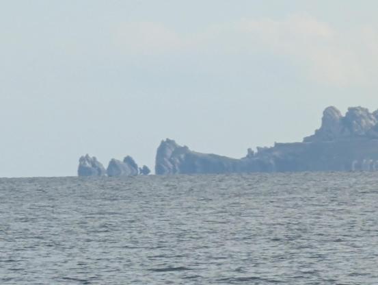 Cap des Mèdes à Porquerolles : vue depuis le nord, la pointe rocheuse comprend un rocher semi-isolé dont la forme fait fortement penser à un poisson qui volerait au-dessus de l'eau.