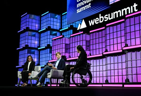 A profile shot of Preety, Otto and Caterina on stage in Lisbon under the Web Summit logo, in front of a large crowd.