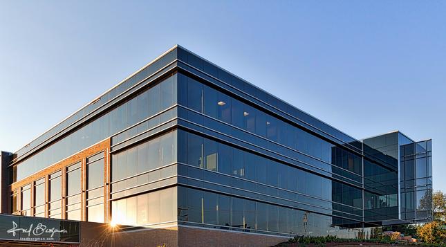 Newly constructed office building with glass walls that reflect the setting sun in Brentwood, TN