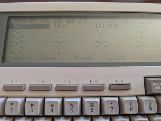 A close up of the LCD screen of my beloved NEC PC 8201a. Showing the "desktop" with various apps.