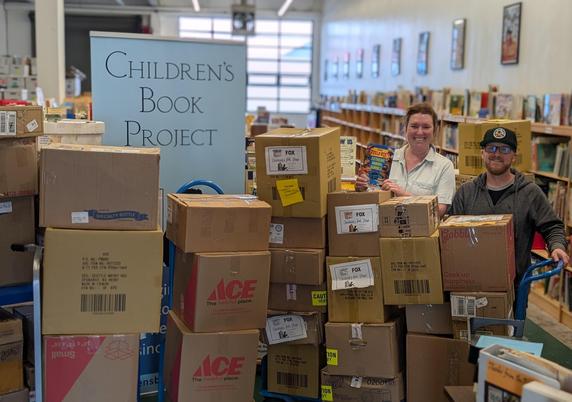 Team from Cole Hardware behind boxes of books donated to the Children's Book Project.