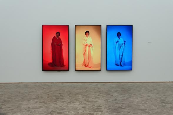 Three screens with different colors and a woman on display