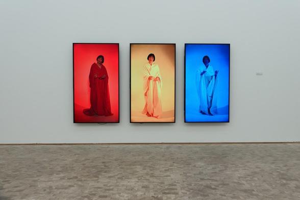 Three screens with different colors and a woman on display