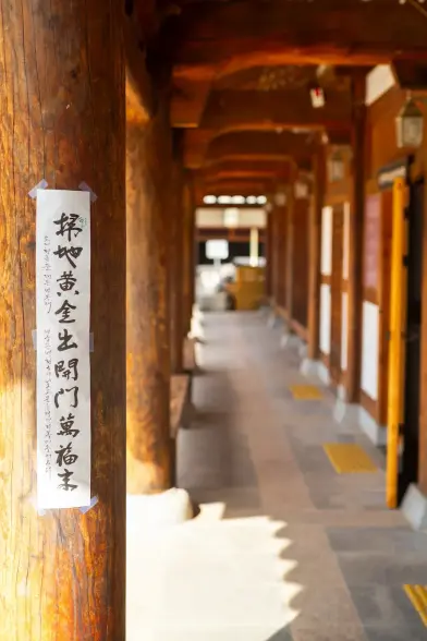 Traditional wooden house pillar with written characters on a poster