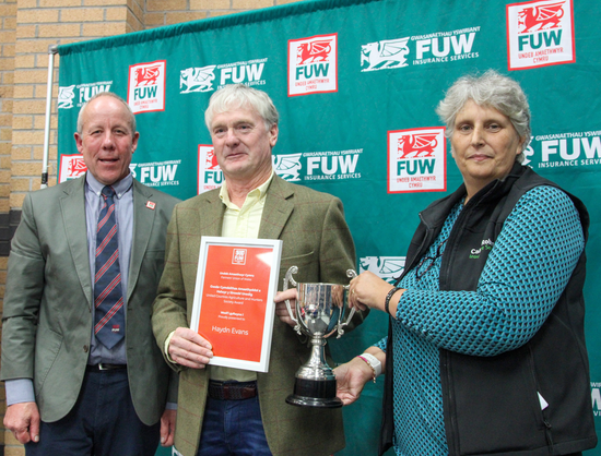 Photograph of Carmarthenshire farmer Haydn Evans receiving the 2025 FUW–United Counties Agriculture and Hunters Society Award at Carmarthen Market.