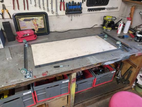 Garage creeper metal and wood pieces cut to size on a workbench.