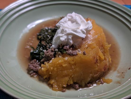 a serving of peeled pumpkin topped with Greek yogurt, in a green pasta bowl