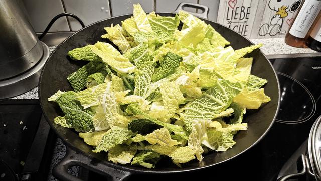 Wirsing Stücke in einem Wok, man sieht die typischen Blattstrukturen