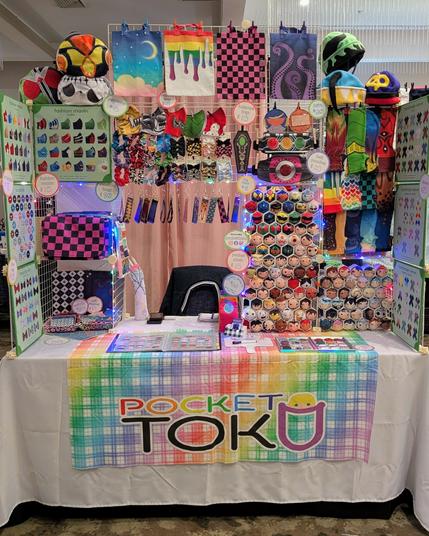 the Pocket Toku booth featuring plush, sleeves, and a multitude of other handmade fabric goods