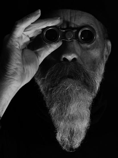Portrait d'un homme barbu avec des jumelles.