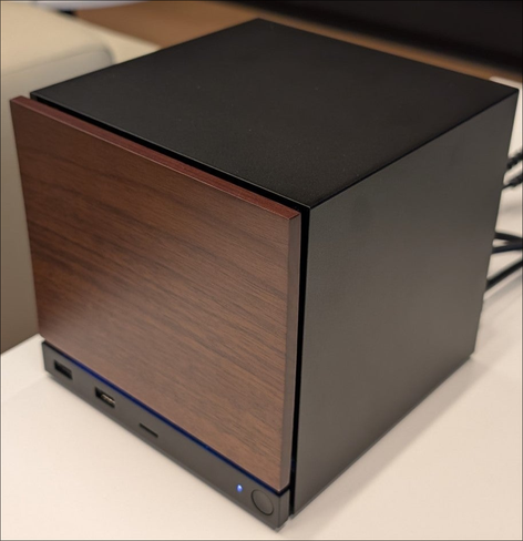 Picture of the newly announced Steam machine. Featuring a Cube shaped computer with wood paneling front.