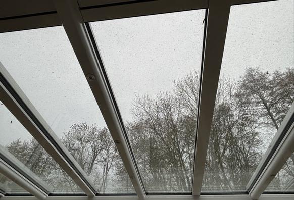 Wintergartendach bedeckt mit Verbrennungsrückständen von Holzofen.