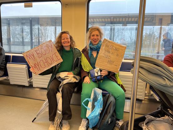 Twee vrouwen in het groen met protesteerden: “my body my choice” en “ik stond hier al in 1980… pffff…”