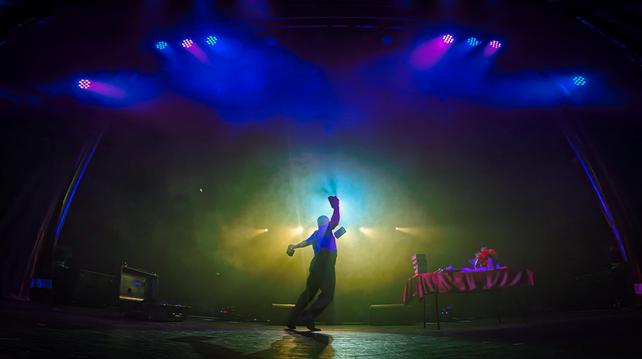 Me, sillhouetted by a spotlight, from behind, hitting a move with my cigar boxes, on stage at the Hunstanton Princess Theatre.
