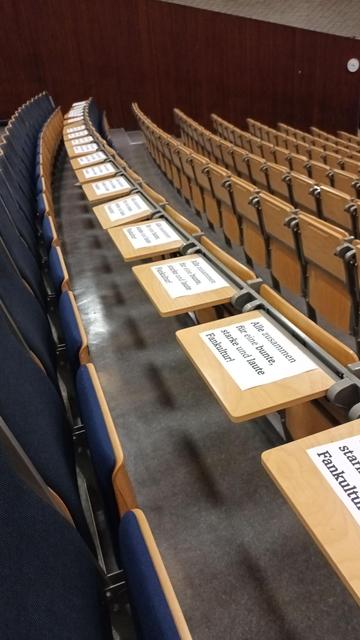 Ausgelegte Schilder bei der MV des Fc St. Pauli im Audimax: "Alle zusammen für eine bunte, starke und laute Fankultur"